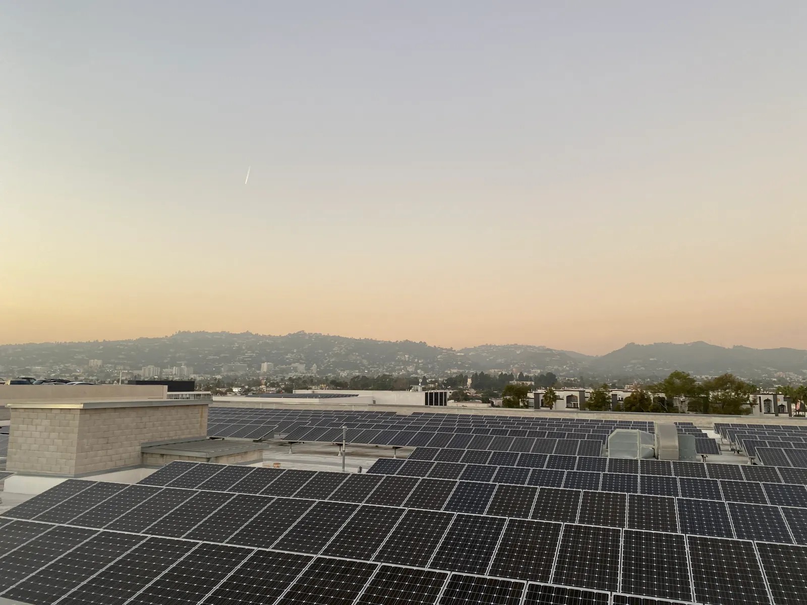 Rooftop solar panels catching the last light of the day