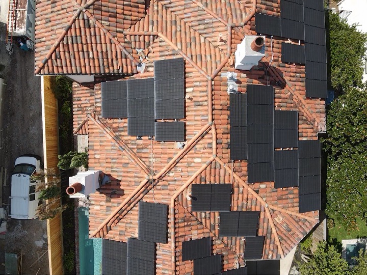 Aerial view of solar arrays installed on a clay tile roof